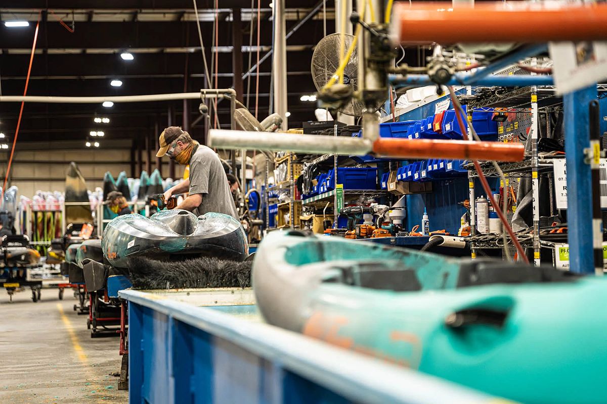 Man working on production line of Old Town kayak in factory